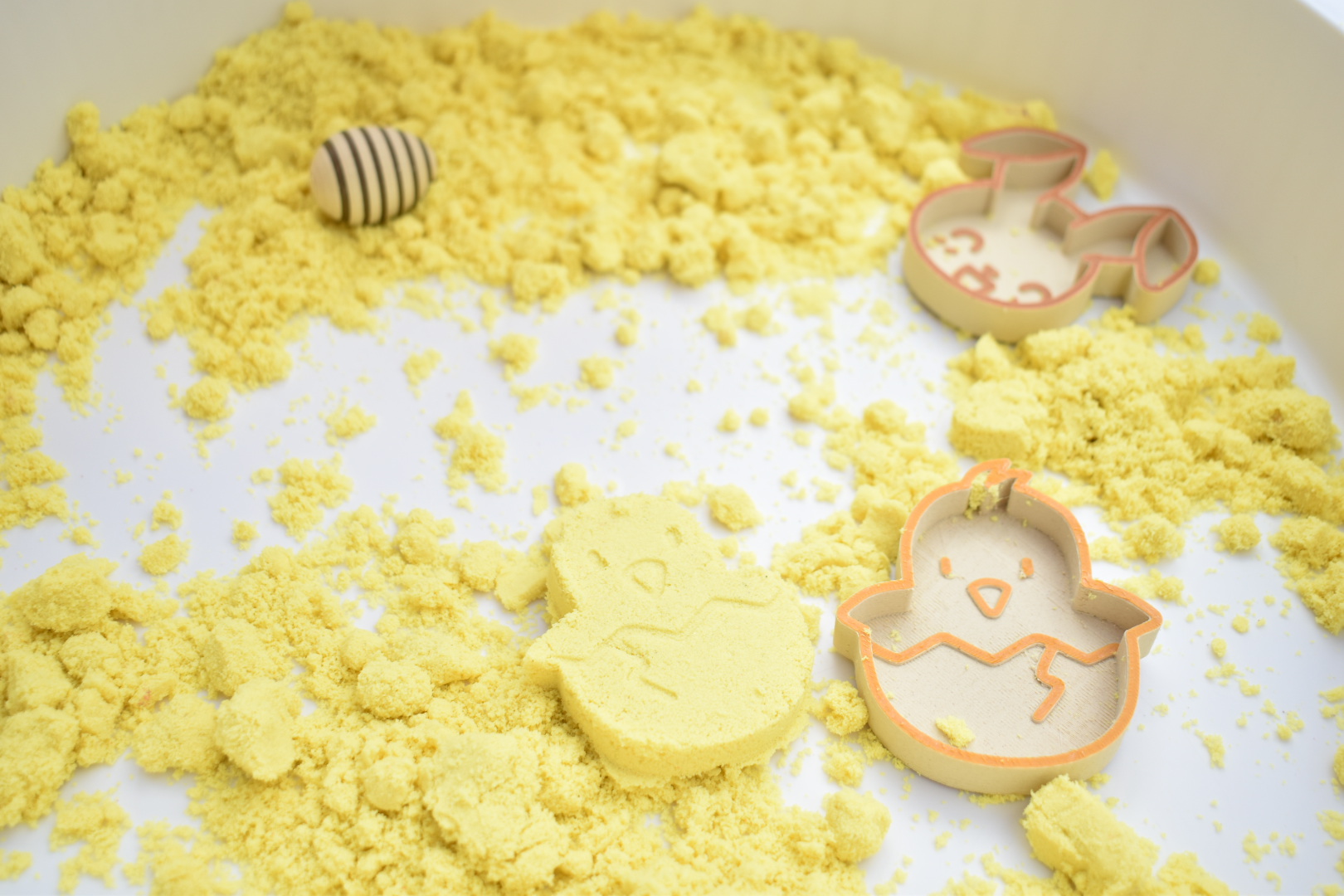 sensorisch spel, sensorisch speelgoed, sensorische tafel, speeltijst, kinetisch zand, vulvormen, vulvormen pasen, paasvormen, kuikentje vulvorm, vulvorm paashaas, rinkelende paaseitjes, houten speelgoed pasen, paasttafel